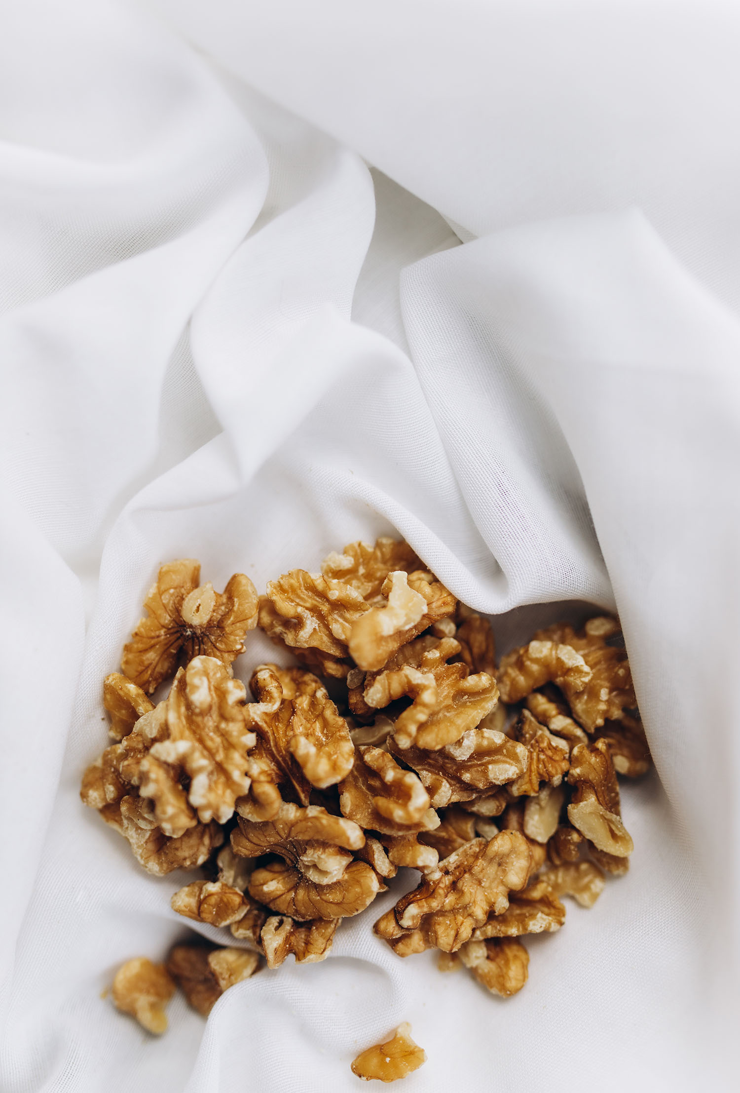 A pile a walnuts on a white cloth